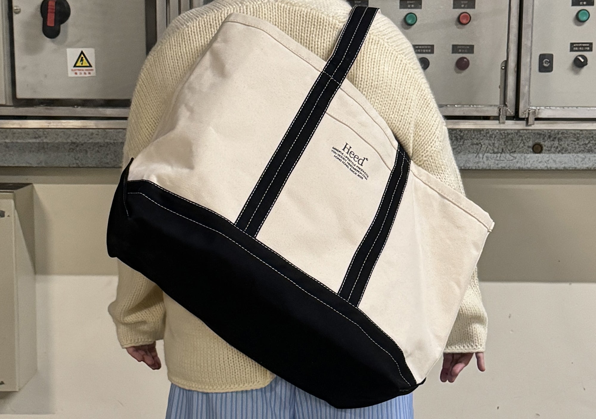 Heed Timeless Boat Tote - Premium Canvas Beach & Travel Bag:  Overhead view of the Heed Timeless Boat Tote in natural cotton canvas. The image highlights the premium 22oz canvas construction, reinforced double-layer base, and overlapped, double-stitched seams for exceptional durability. The shoulder-use handles and subtle black accents are also visible, showcasing the tote's classic, yet contemporary design.